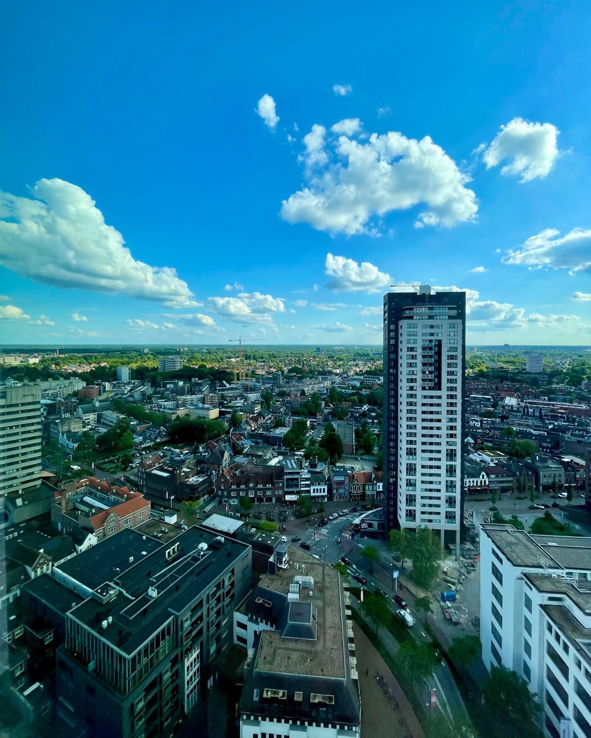 Woontoren boven een binnenstad met winkels en woningen eromheen: een complex waarvan de conditiemeting, het meerjarenonderhoudsplan en de meldingen van bewoners in één dossier staan